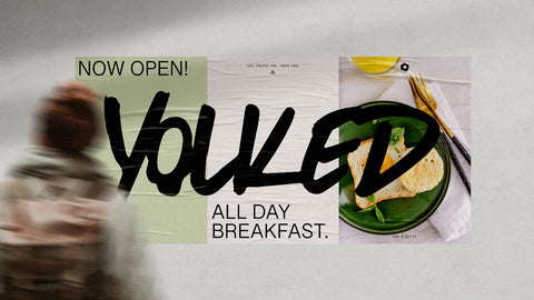 Poster showing advertising for an all-day breakfast restaurant and a blurry person walking in the foreground