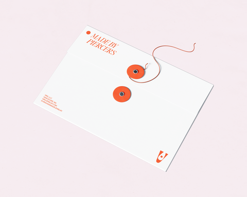 White envelope with orange accents, and a string to close the envelope