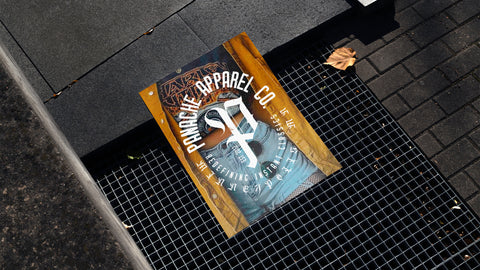 Magazine lying on sidewalk floor, on top of metal grate