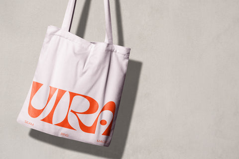 White tote bag hanging with Vira's logo